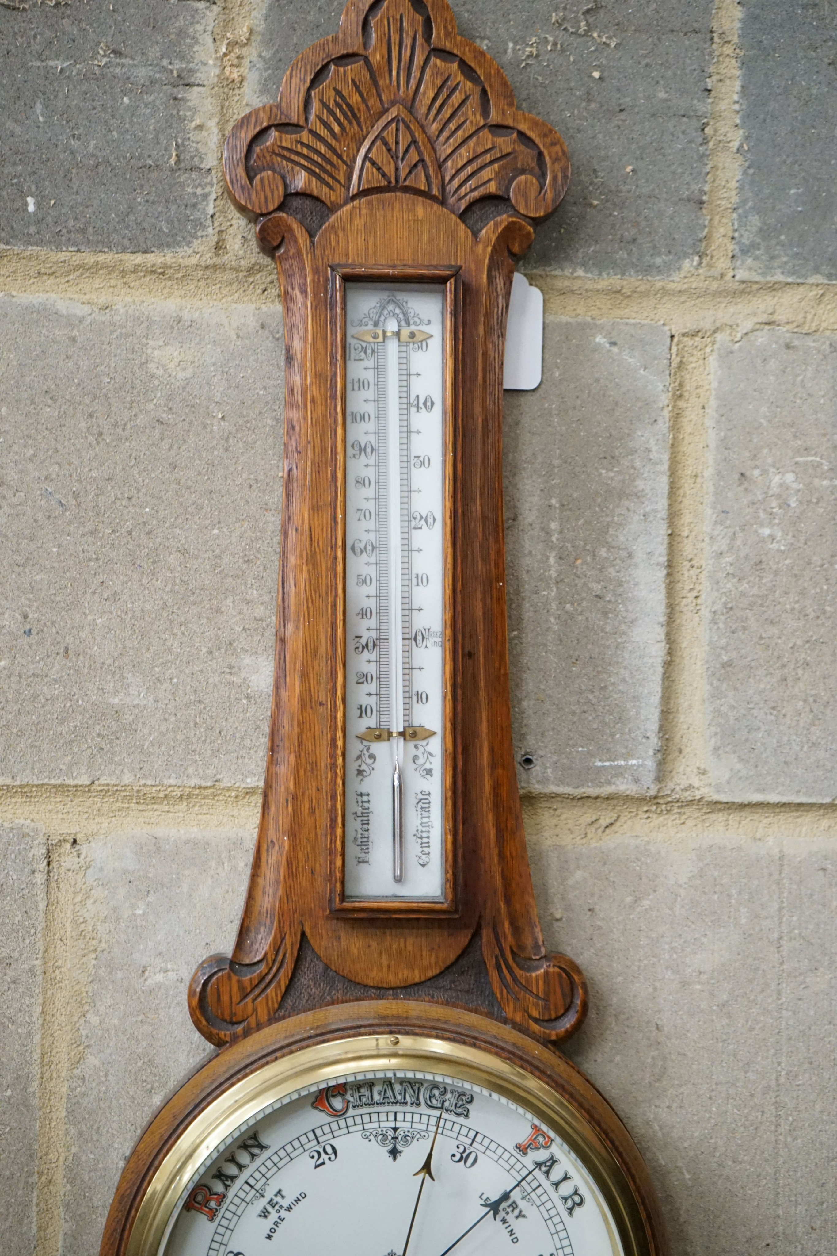 A late Victorian carved oak aneroid barometer and thermometer, height 84cm